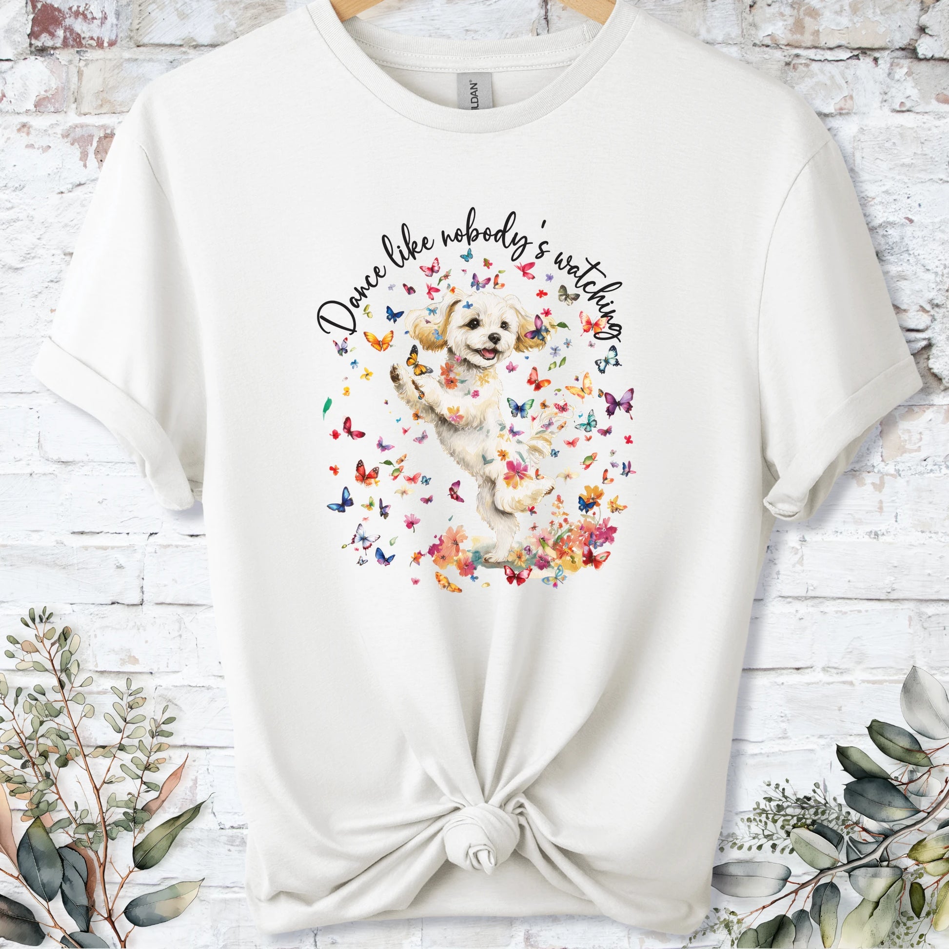 https://wescale-cdn.com/generated-mockups/bf472b68-5c1c-44c3-a409-4b955cabfa92/69acafd1-585e-4806-952c-4f06a54c82f8/3e8a5956-7015-46e5-b1dc-8a0d0bd2176b_designs/maltese_2_dance_like_nobody_s_watching_unisex_t_shirt_2_1777545846776_ywuo0g.png_1777545848162.webp