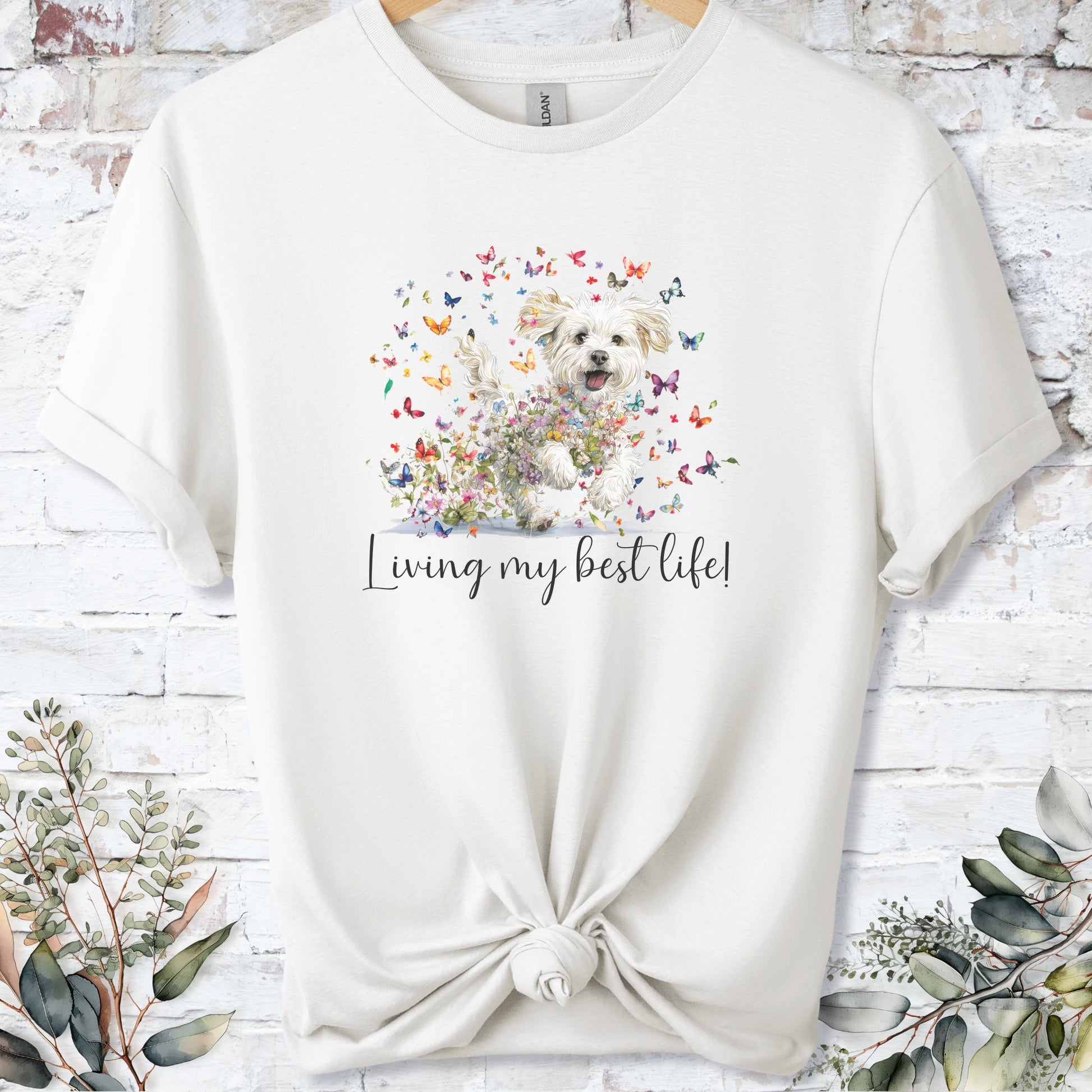 https://wescale-cdn.com/generated-mockups/bf472b68-5c1c-44c3-a409-4b955cabfa92/69acafd1-585e-4806-952c-4f06a54c82f8/3e8a5956-7015-46e5-b1dc-8a0d0bd2176b_designs/maltese_living_my_best_life_2_unisex_t_shirt_2_1777545790833_1vlrjs.png_1777545793187.webp